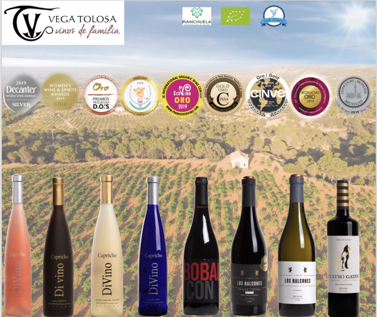 Una selección de vinos de Vega Tolosa con varias medallas de premio al frente de un viñedo en la región de la Manchuela.